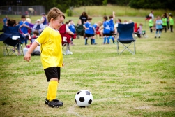 Young child boy playing soccer during organized league game